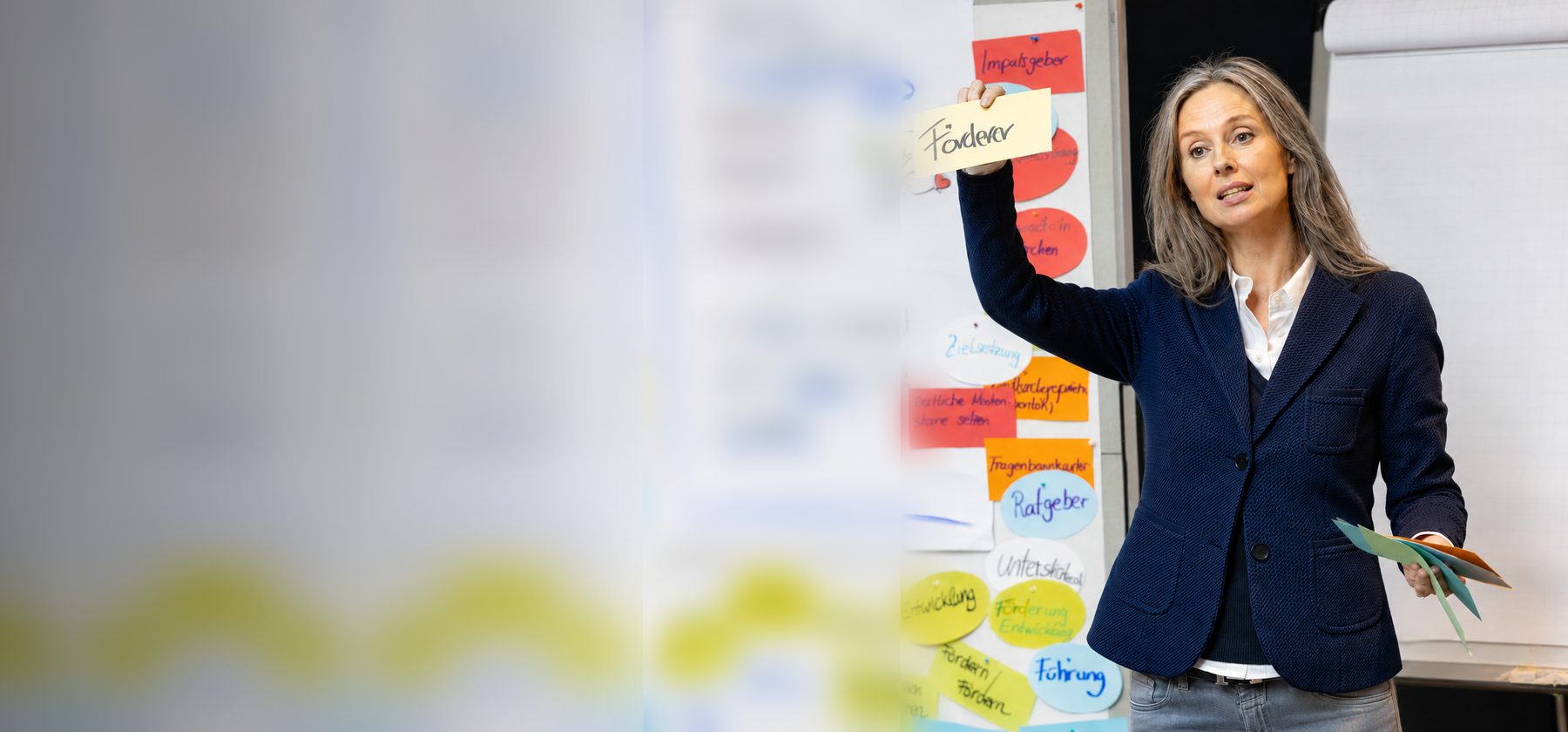 Sonja Neitzel-Bothe im Workshop, hält ein Post-It mit der Aufschrift Förderer